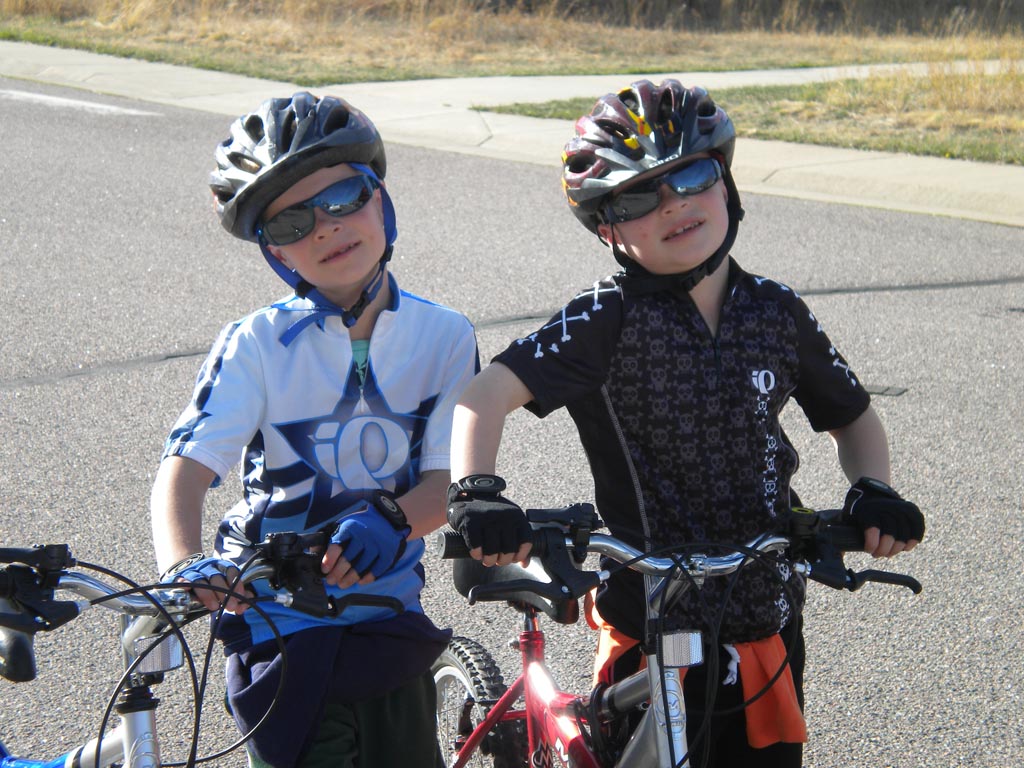Twin boys wearing helmets with mountain bikes 